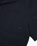 Close up view of Uskees dark blue Cuban shirt for men with focus on the chest pocket and Uskees label tab.