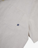Close up view of Uskees off-white Cuban shirt for men with focus on the chest pocket and Uskees label tab.