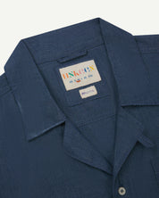 Close-up and angled front view of the 6004 Cuban utility shirt showing the texture of the breathable organic chambray cloth, collar, lapels and Uskees brand label.