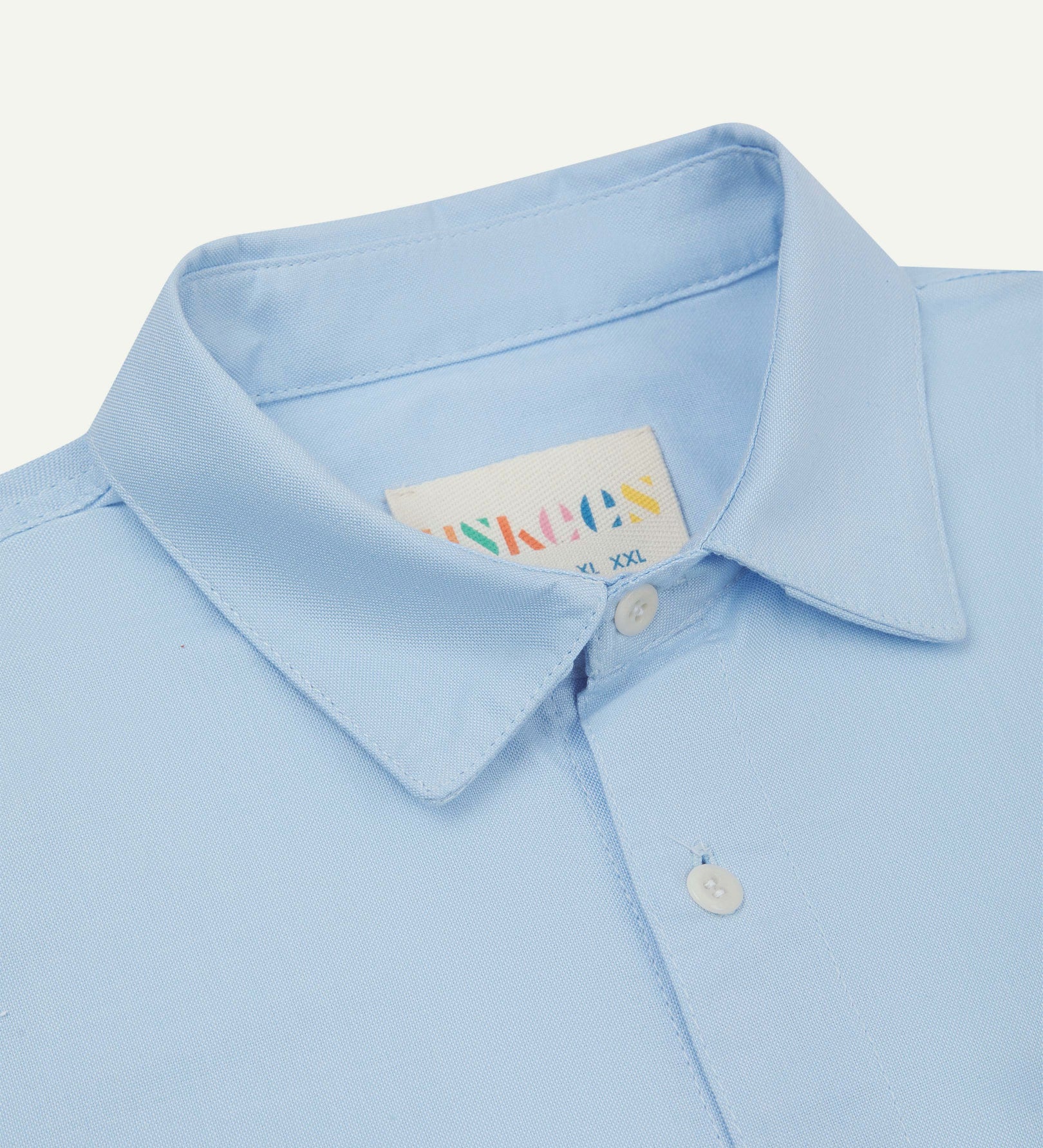 Close-up and angled front view of the 6006 Oxford shirt showing the texture of the organic cotton, the collar and Uskees brand label.