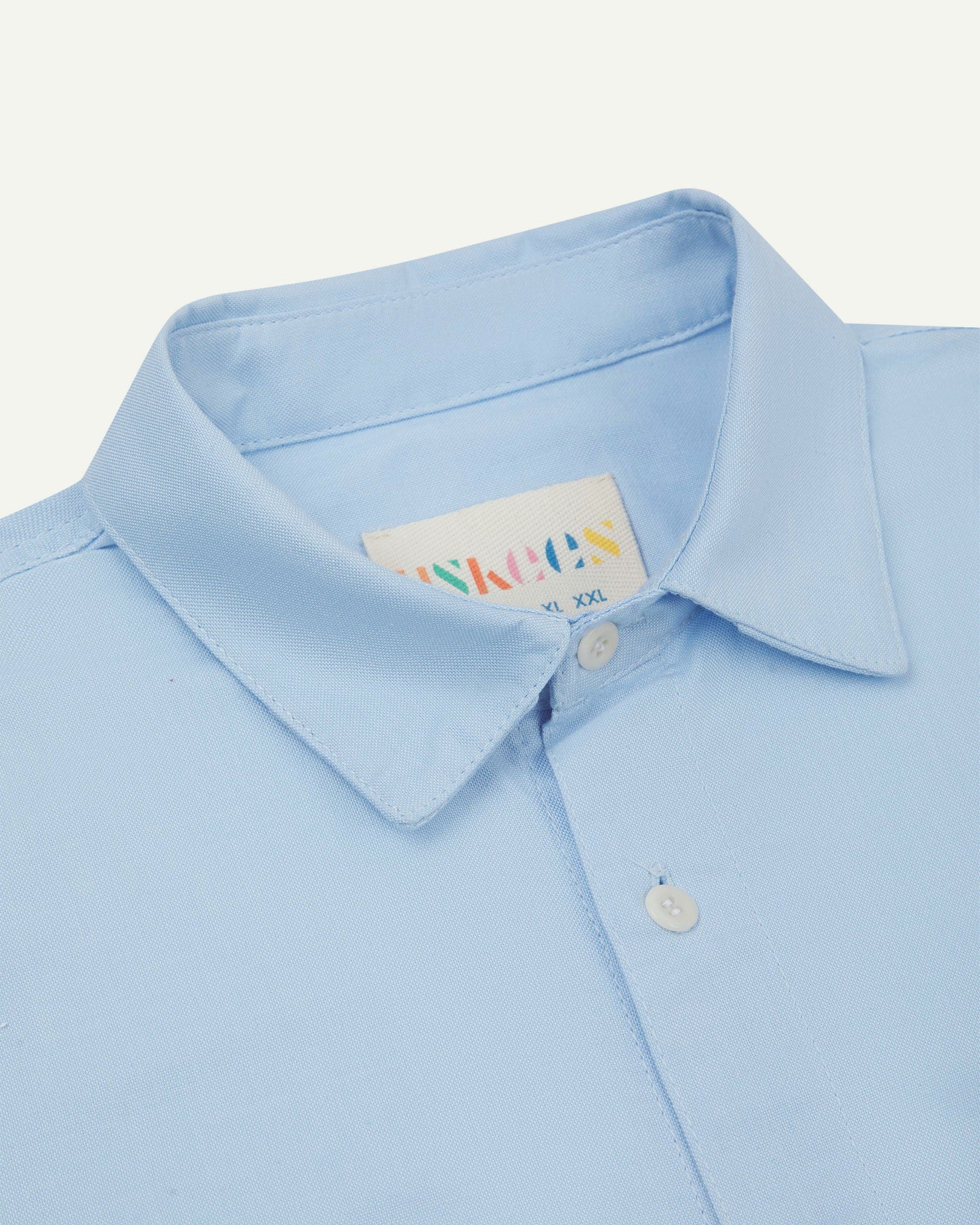 Close-up and angled front view of the 6006 Oxford shirt showing the texture of the organic cotton, the collar and Uskees brand label.