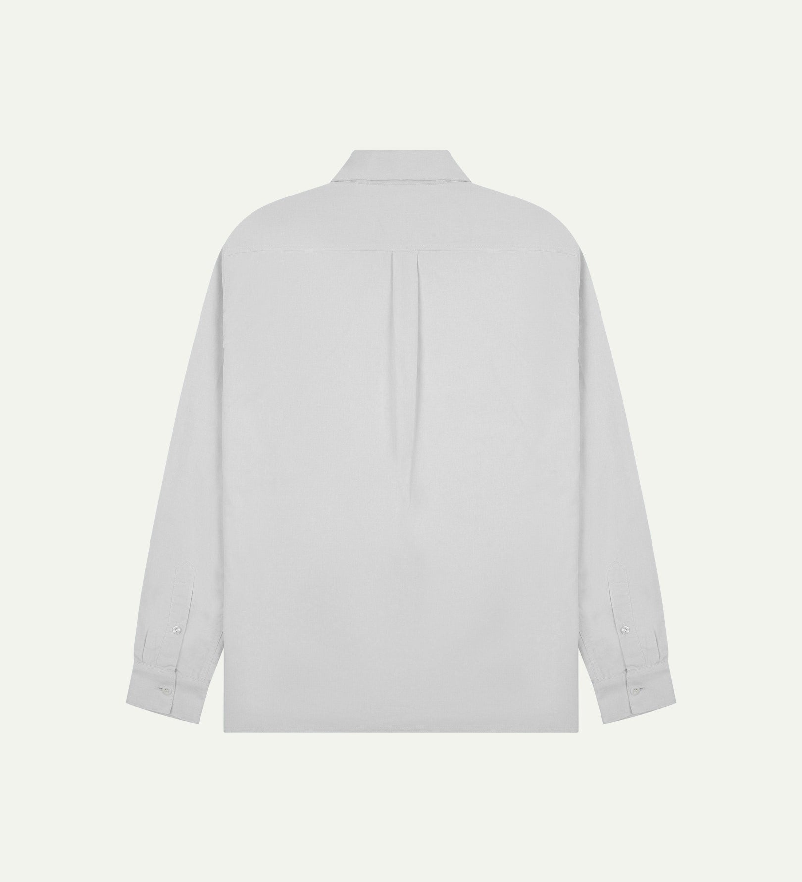 Flat back view of white organic cotton Oxford shirt from Uskees with view of open pleat and longer rear hem so it can be tucked in more easily.