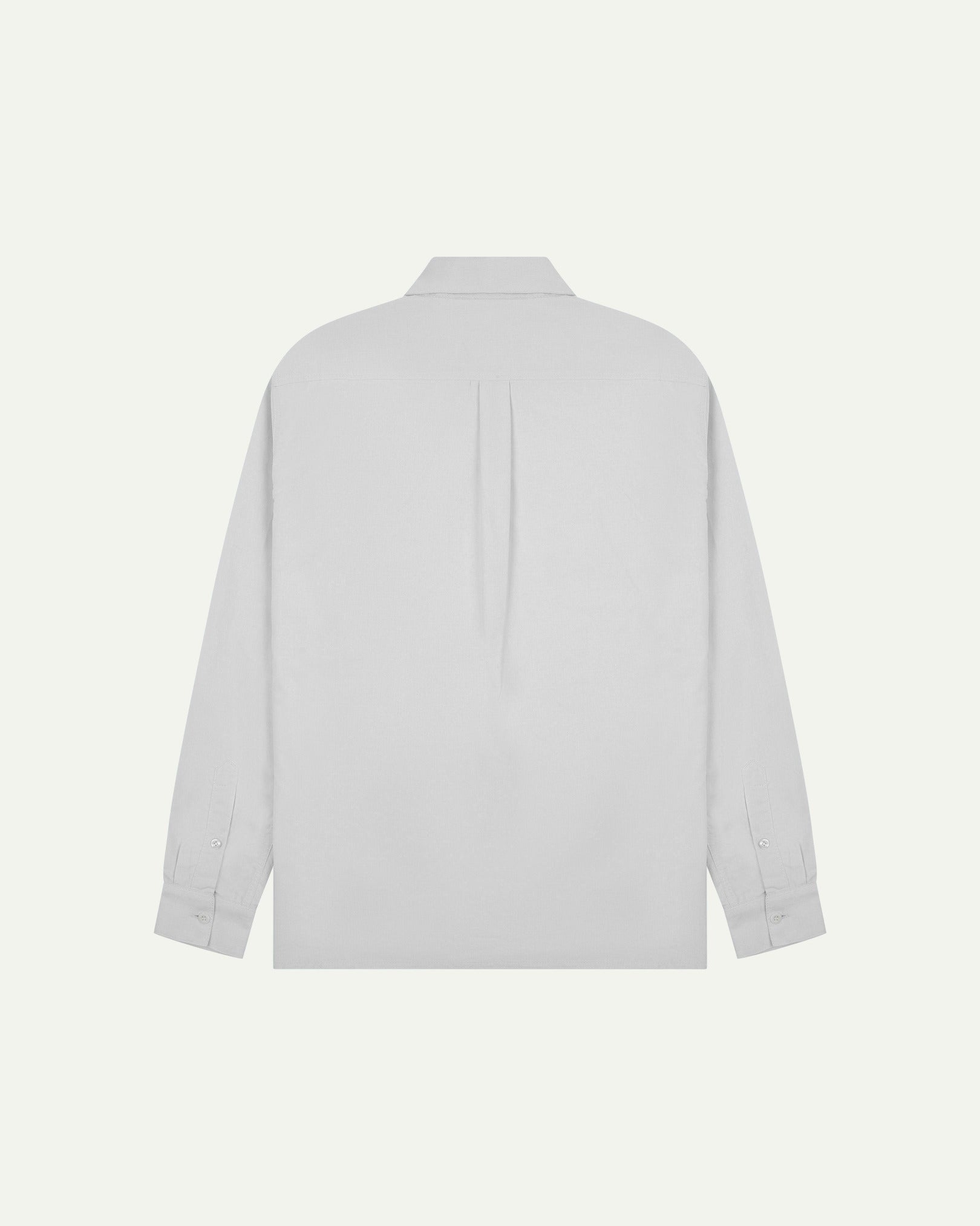 Flat back view of white organic cotton Oxford shirt from Uskees with view of open pleat and longer rear hem so it can be tucked in more easily.