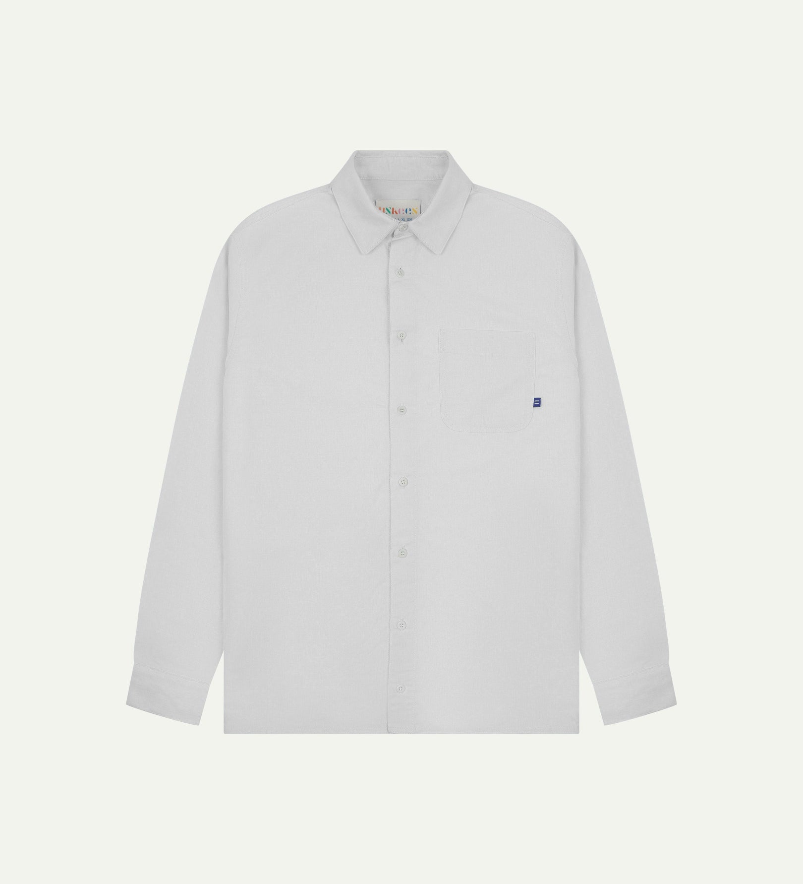 Flat front view of white organic cotton Oxford shirt from Uskees. Clearly showing loose fit and 8-button front.