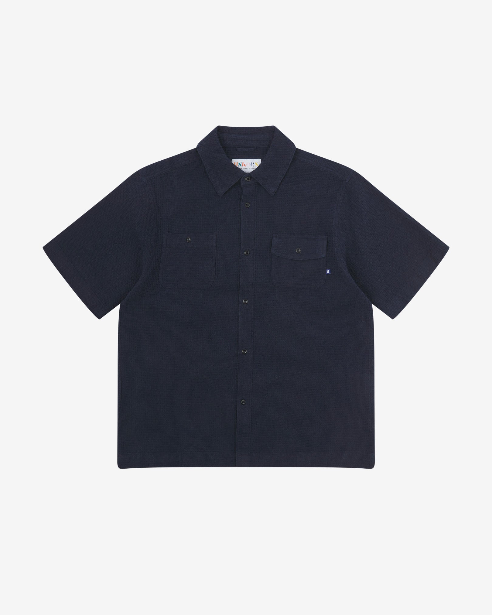 Front flat view of Uskees Tasker buttoned short sleeve shirt with deep blue organic cotton waffle fabric.