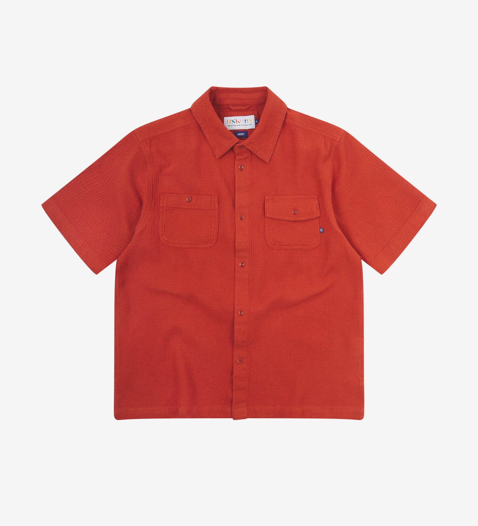 Front flat view of Uskees Tasker buttoned short sleeve shirt with rust-red organic cotton waffle fabric.