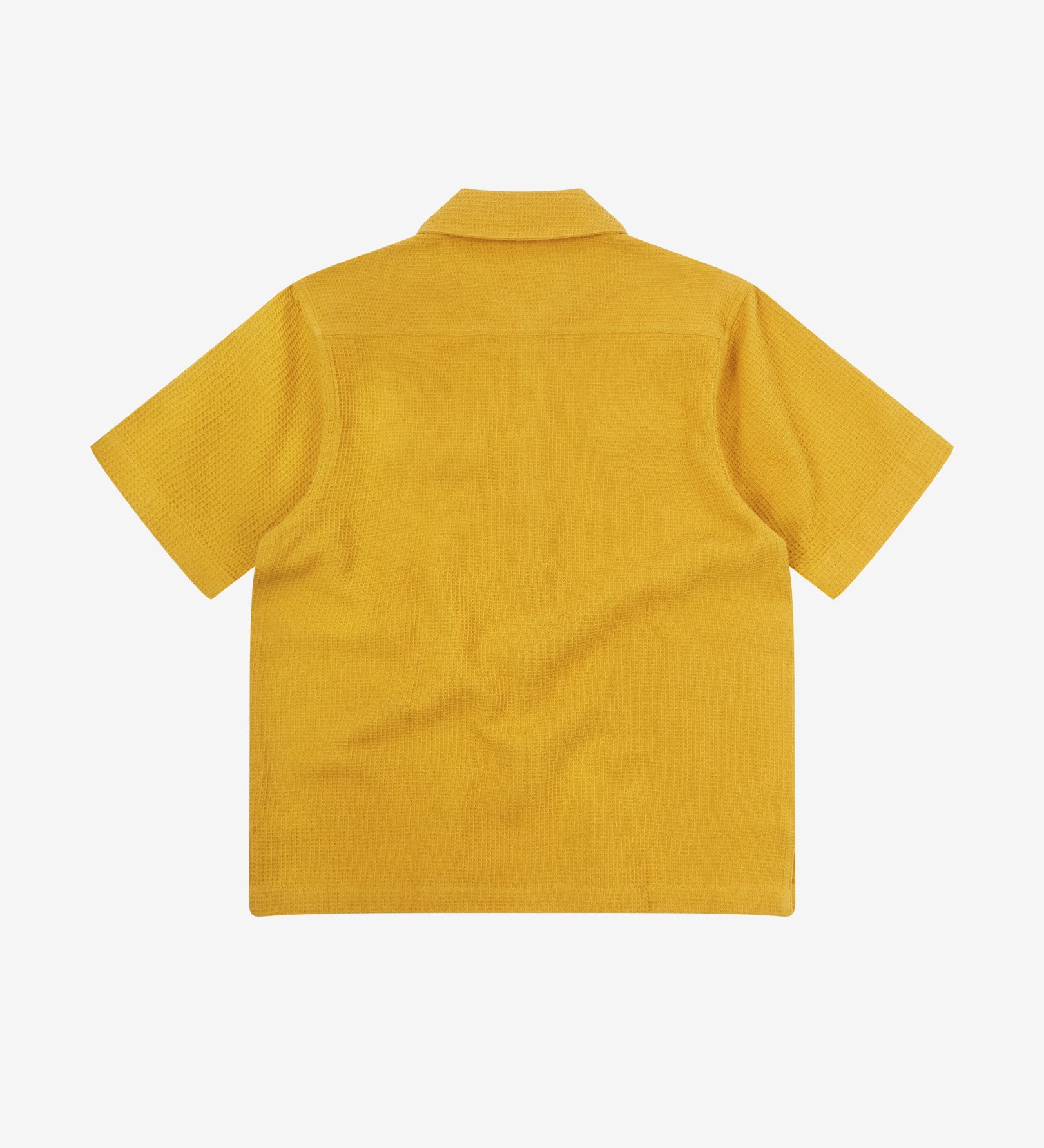 Reverse flat view of yellow organic cotton waffle fabric short sleeve shirt from Uskees showing vent in hem and loose, relaxed silhouette.