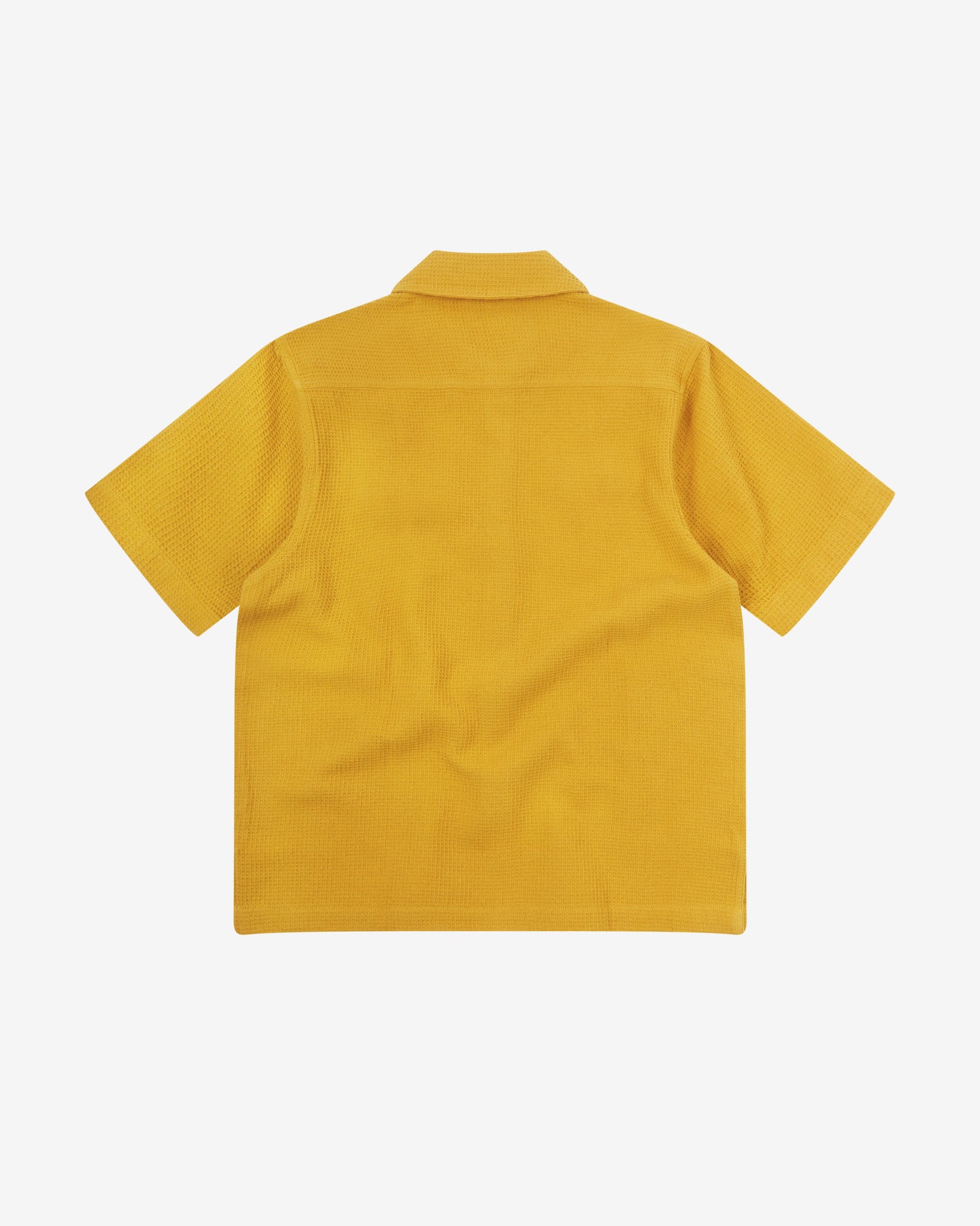 Reverse flat view of yellow organic cotton waffle fabric short sleeve shirt from Uskees showing vent in hem and loose, relaxed silhouette.