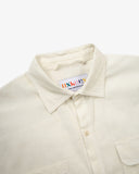 Front close up shot of Uskees cream linen blend short-sleeve shirt for men showing the bran label at the neck.