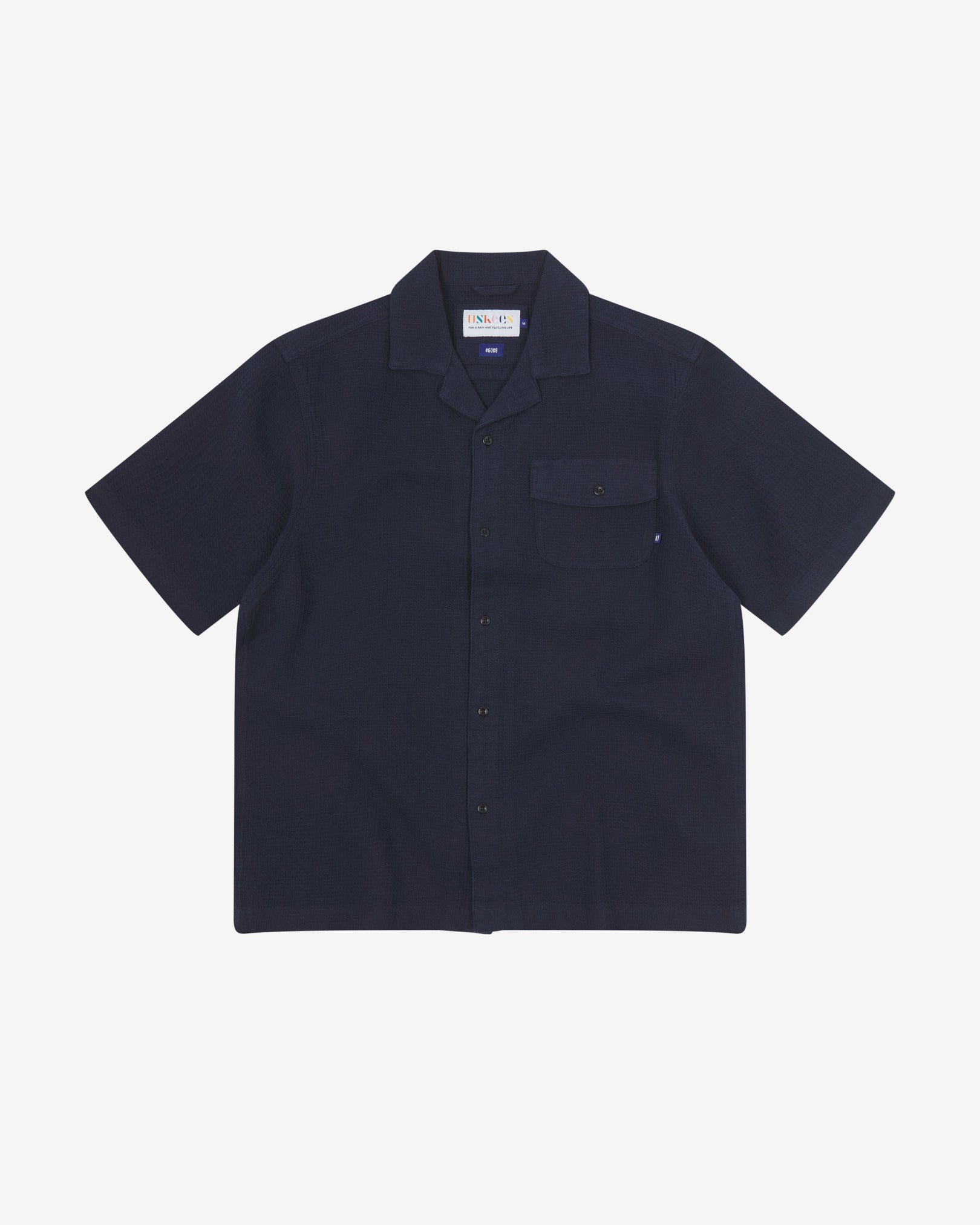 Front flat view of Capri Camp buttoned short sleeve shirt from Uskees with deep blue organic cotton waffle fabric.