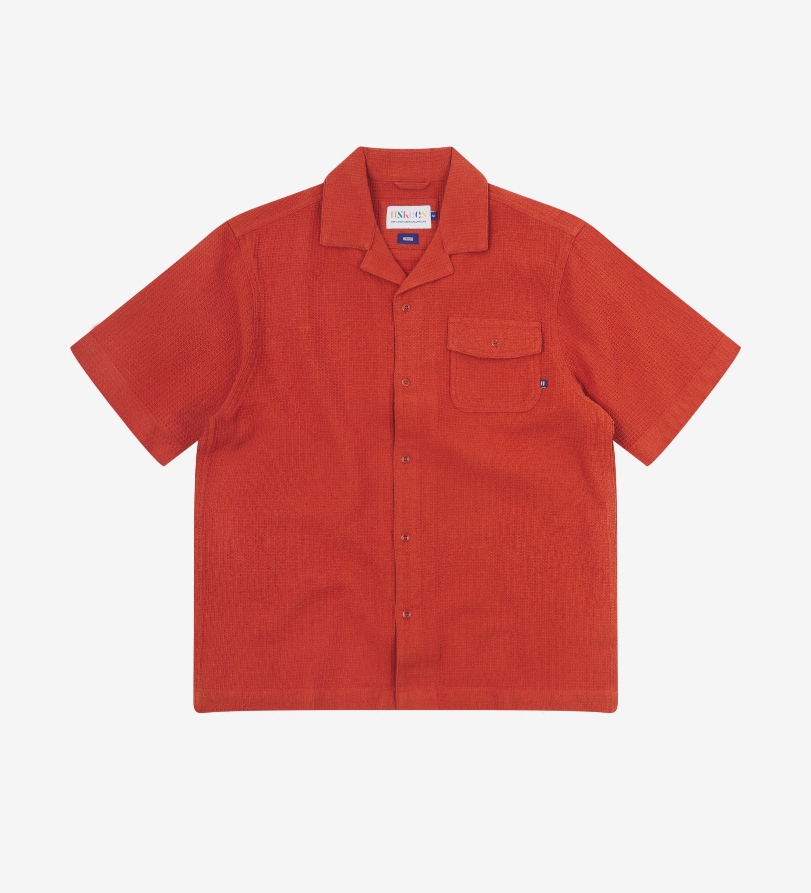 Front flat view of Capri Camp buttoned short sleeve shirt from Uskees with rust-red organic cotton waffle fabric.