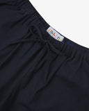 Close-up shot of Uskees dark blue shorts with focus on the brand label and drawstring waist.