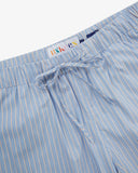 Close-up shot of Uskees blue, gold and white striped shorts with focus on the brand label and drawstring waist.