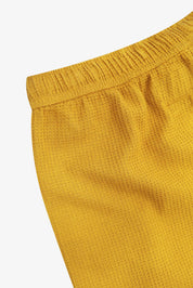 Close-up angled rear view of the #6009 Uskees shorts, presenting a closer view of the elasticated waistband and yellow waffle fabric.