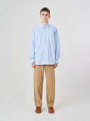 Man wearing Uskees light blue men's Oxford shirt, paired with Uskees khaki pants.