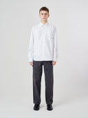 Man wearing Uskees white men's Oxford shirt, paired with Uskees dark grey pants.