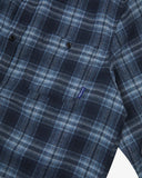 Close up view of an Uskees navy check long sleeved flannel shirt for men showing the chest pocket detail.