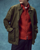 Front view wearing the Uskees wax storm jacket in dark 'Pennine' green. Jacket open, clearly showing the contrasting popper fastenings. 