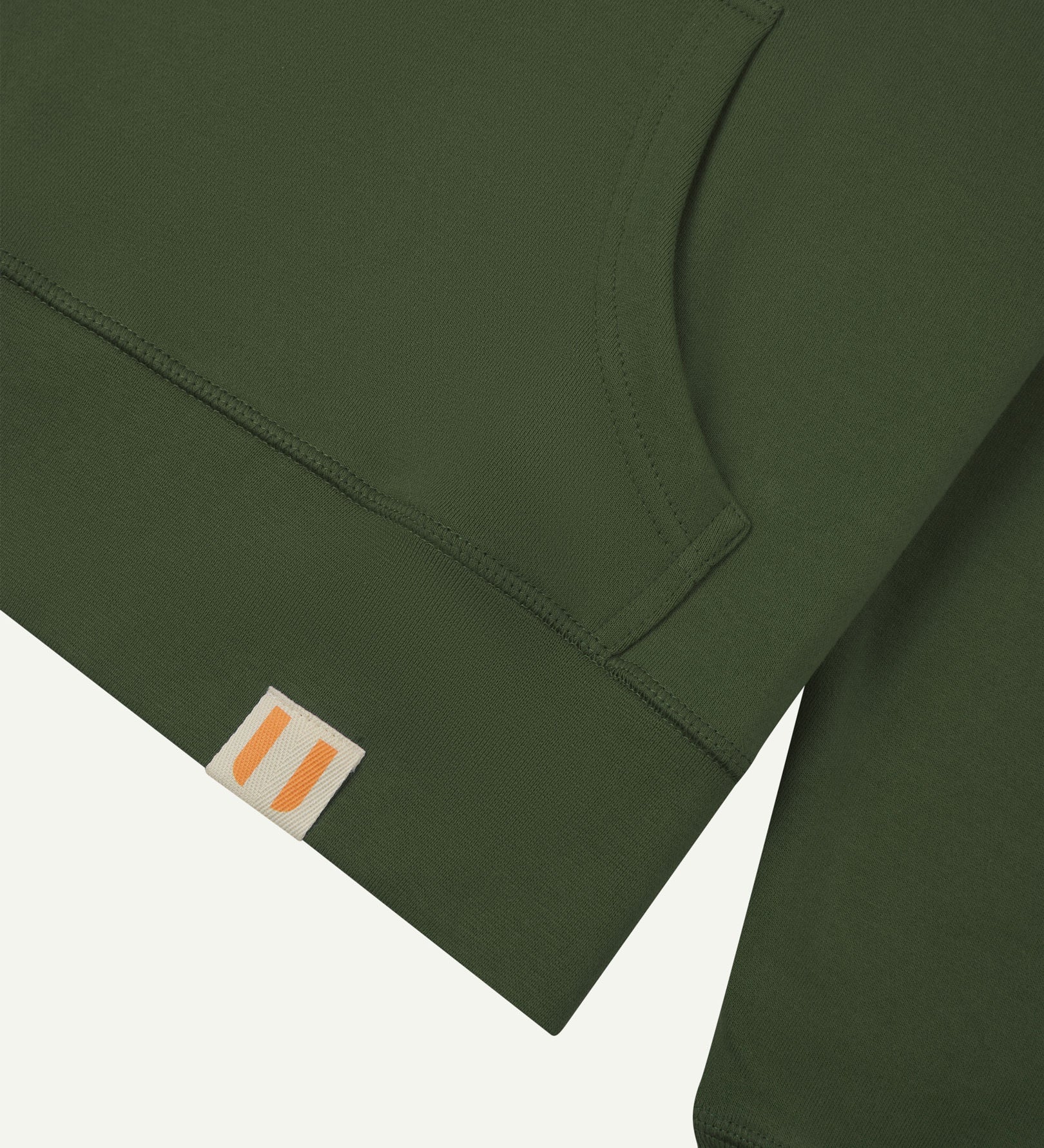 Front close view of Uskees coriander-green hoodie with clear view of brand logo on hem and kangaroo front pocket.