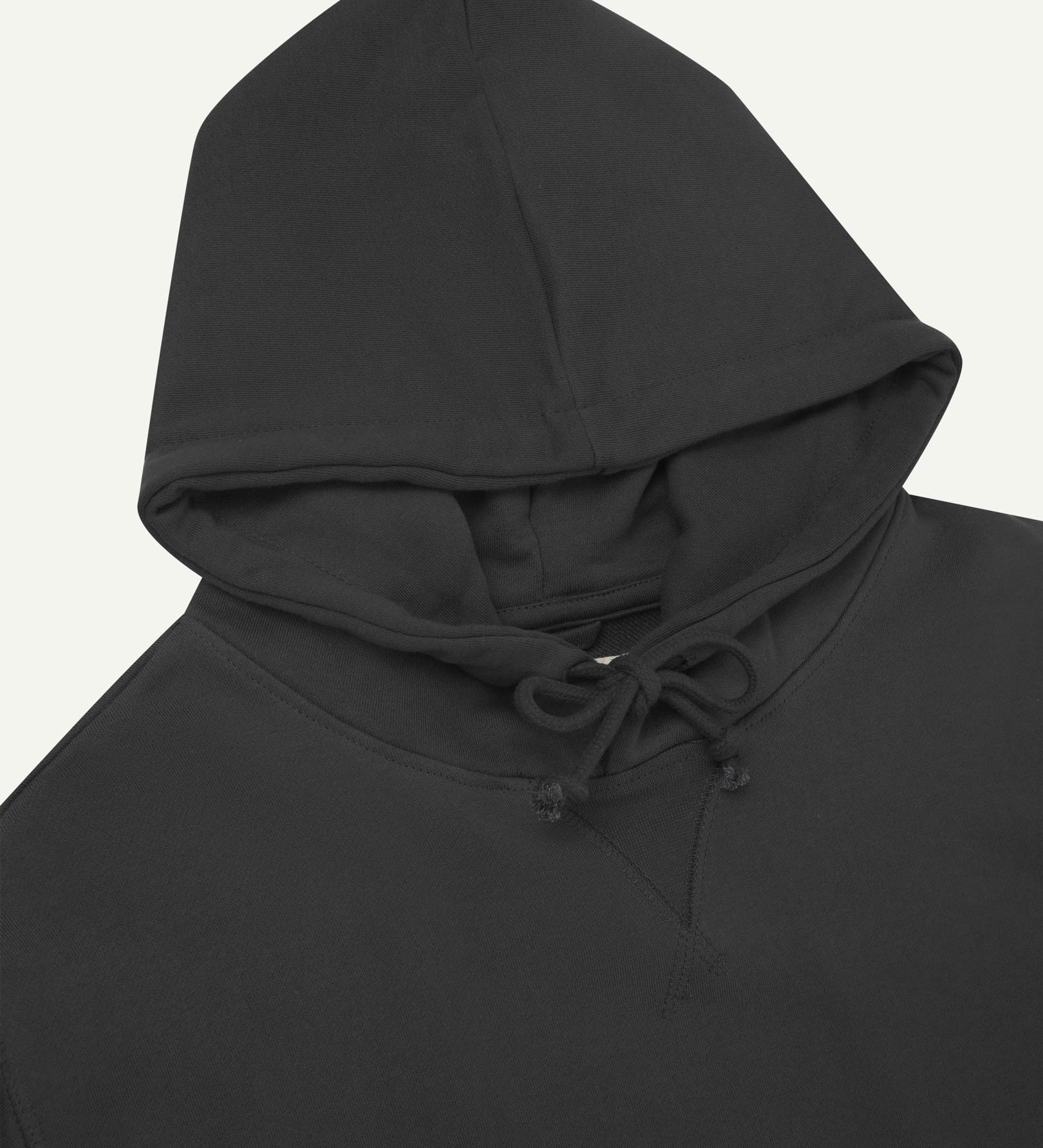 Front close-up view of Uskees 7004 faded black hoodie showing hood tie detail at neck and decorative V pattern.