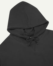 Front close-up view of Uskees 7004 faded black hoodie showing hood tie detail at neck and decorative V pattern.