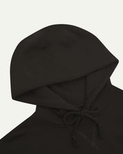 Close up front shot of Uskees signature faded black men's hooded sweatshirt showing the hood and drawstring detail.