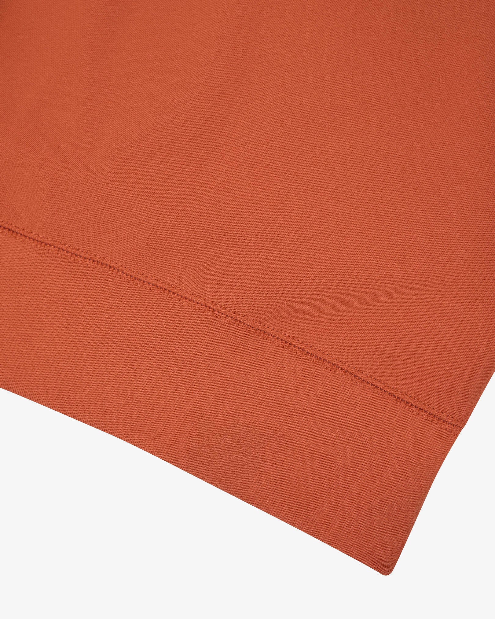 Closer view view of the ribbed hem of the Uskees cinnamon-orange organic heavyweight cotton 7005 jersey sweatshirt.