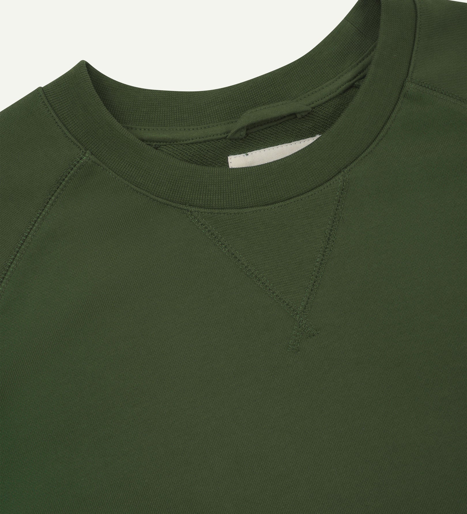 Close-up view of crew neck collar with decorative v-insert on Uskees coriander-green heavyweight cotton jersey sweatshirt.