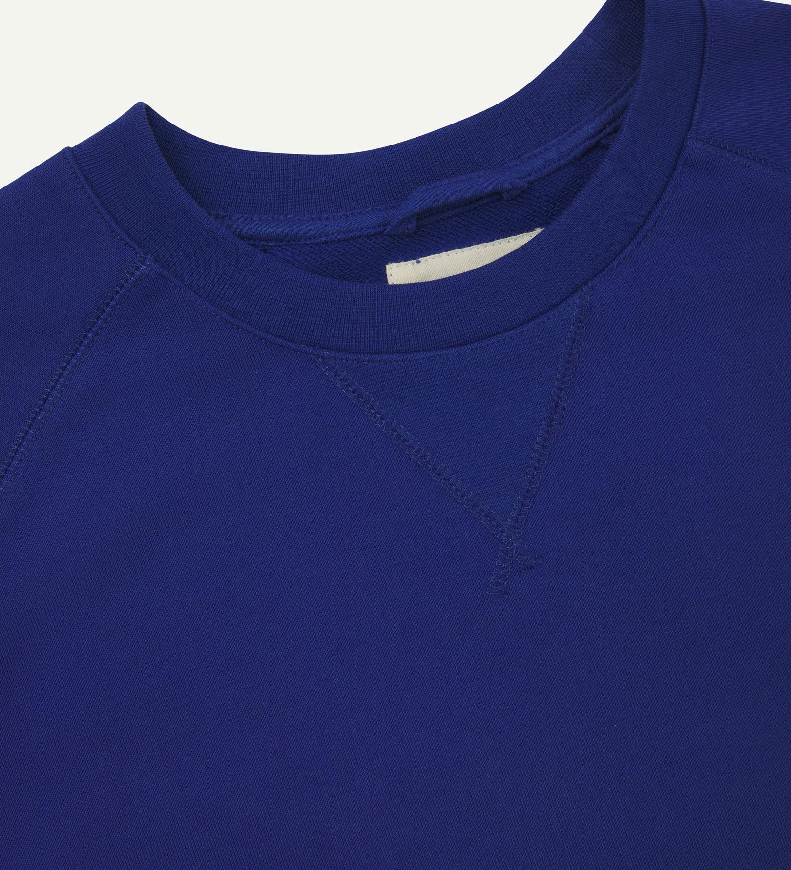 Close-up view of crew neck collar with decorative v-insert on Uskees ultra-blue heavyweight cotton jersey sweatshirt.