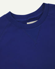 Close-up view of crew neck collar with decorative v-insert on Uskees ultra-blue heavyweight cotton jersey sweatshirt.