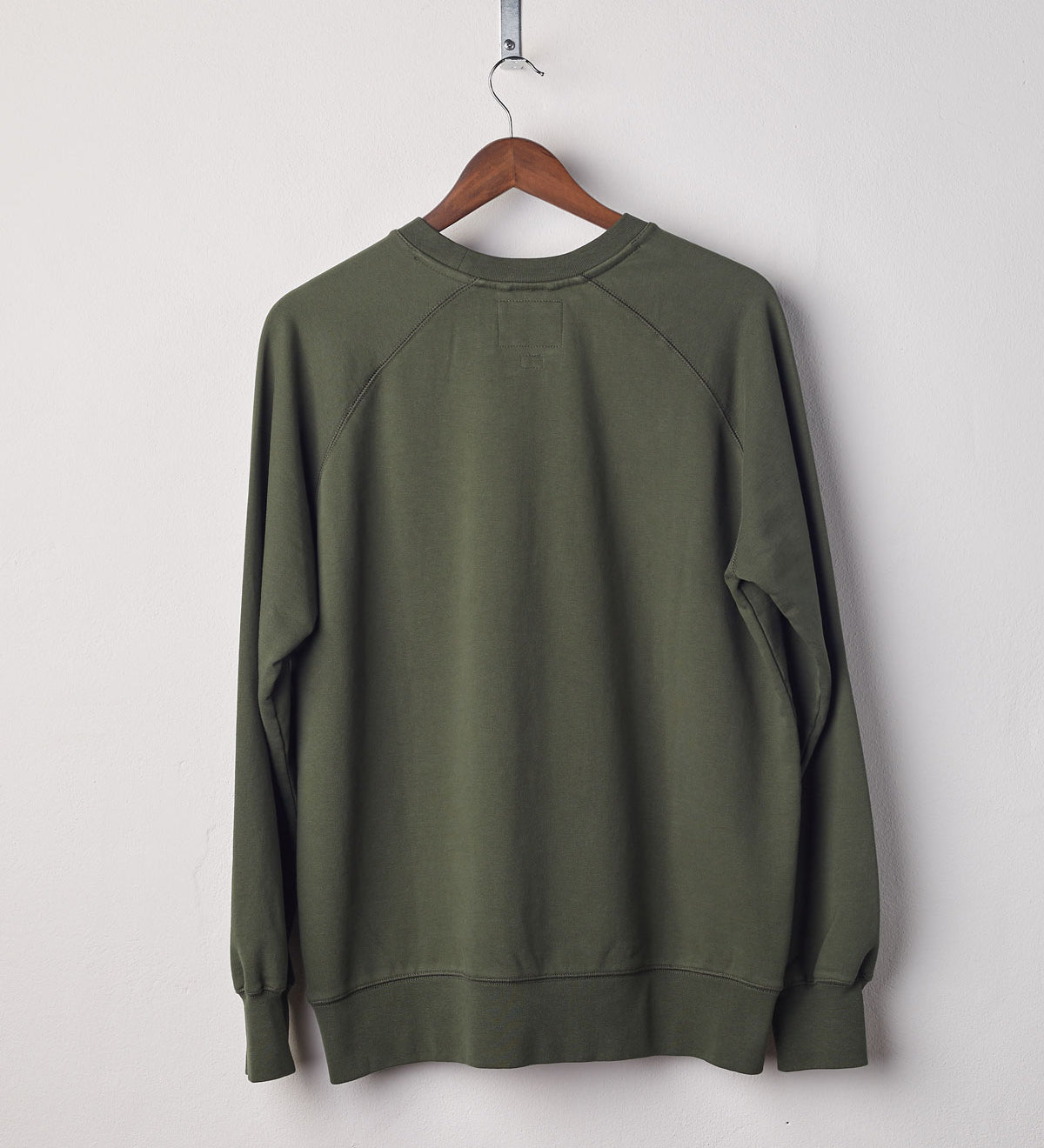 Back view of vine green organic heavyweight cotton #7005 jersey sweatshirt by Uskees presented on hanger.
