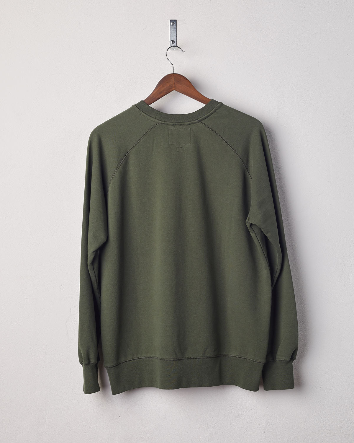 Back view of vine green organic heavyweight cotton #7005 jersey sweatshirt by Uskees presented on hanger.