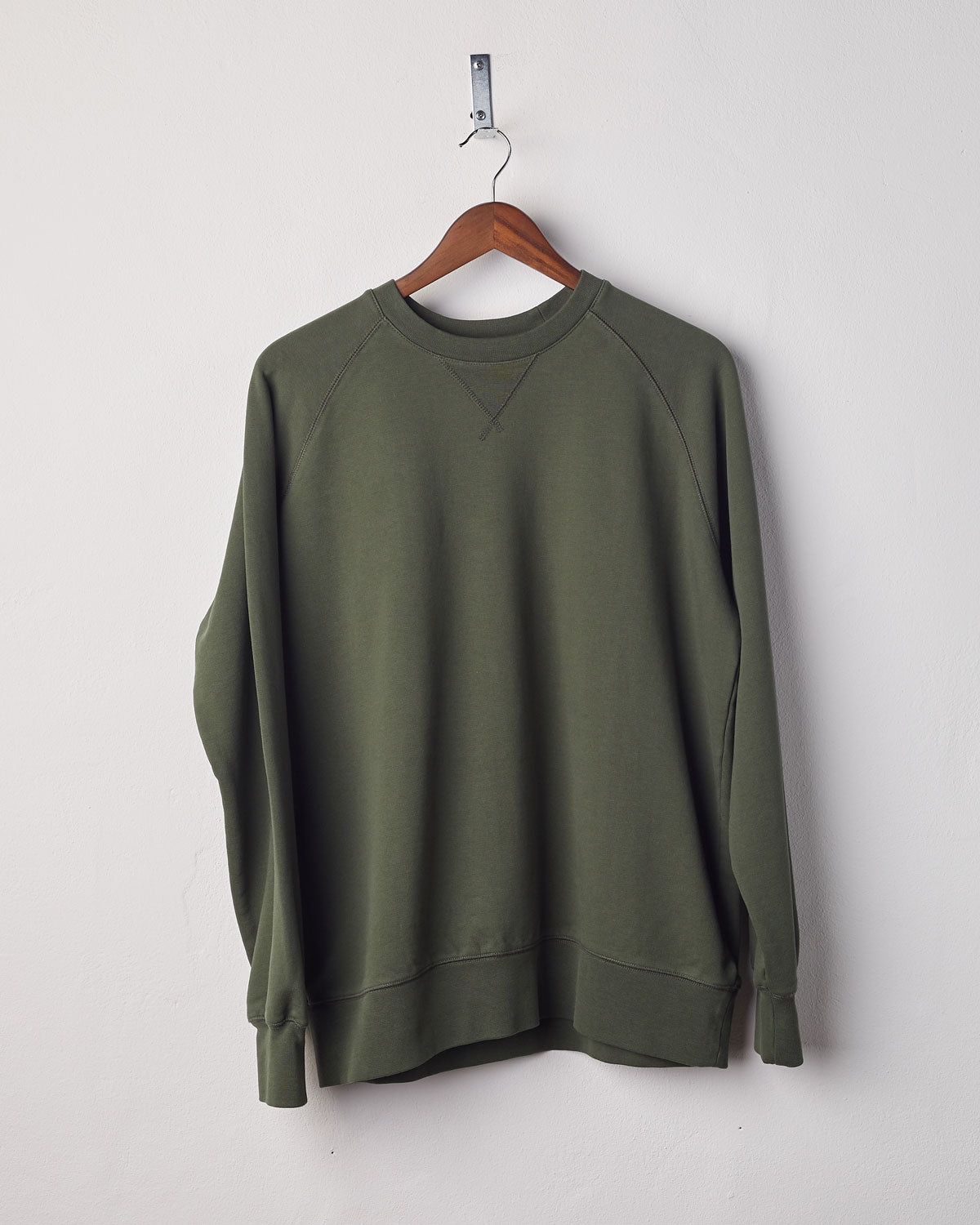 Front view of vine green organic heavyweight cotton #7005 jersey sweatshirt by Uskees presented on hanger.