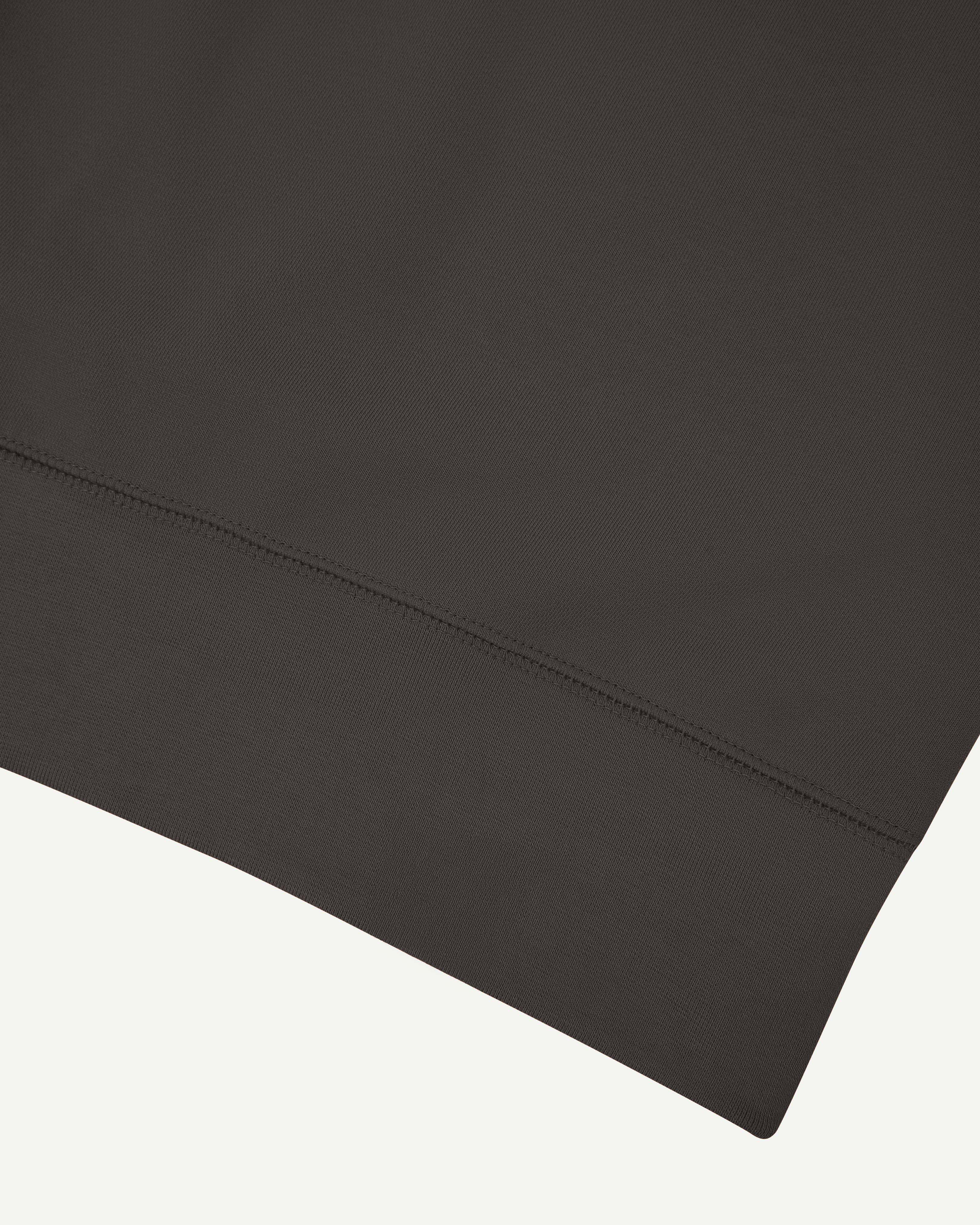 Close up shot of hem on Uskees 7005 crew neck sweatshirt in faded black