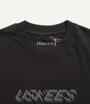 Close-up neckline view of Uskees men's graphic t-shirt in black showing the philips head screw graphic and the texture of the enzyme washed, organic cotton jersey material.