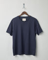 Front view of midnight blue organic cotton #7006 jersey T-shirt by Uskees, presented on hanger against white background. 