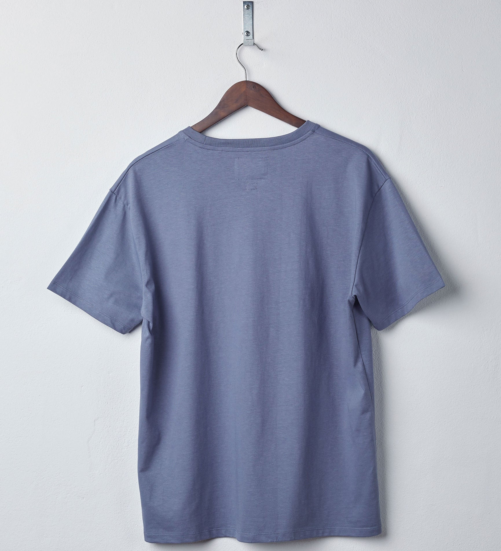 Back view of teal organic cotton #7006 jersey T-shirt by Uskees. Presented on hanger against white background.
