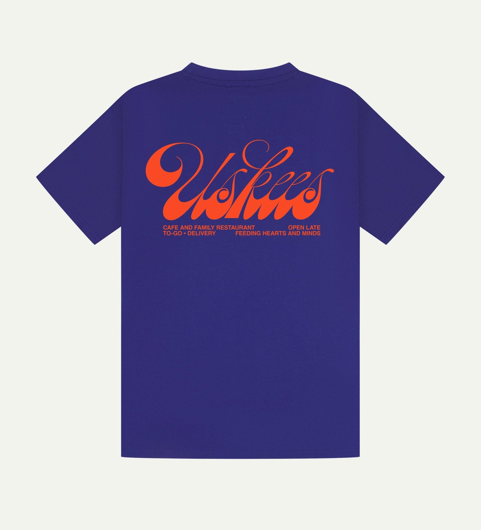 Back flat view of ultra blue organic cotton Uskees short-sleeved T-shirt showing the loose silhouette. Spanning the back is the large, bright orange 'diner' logo.