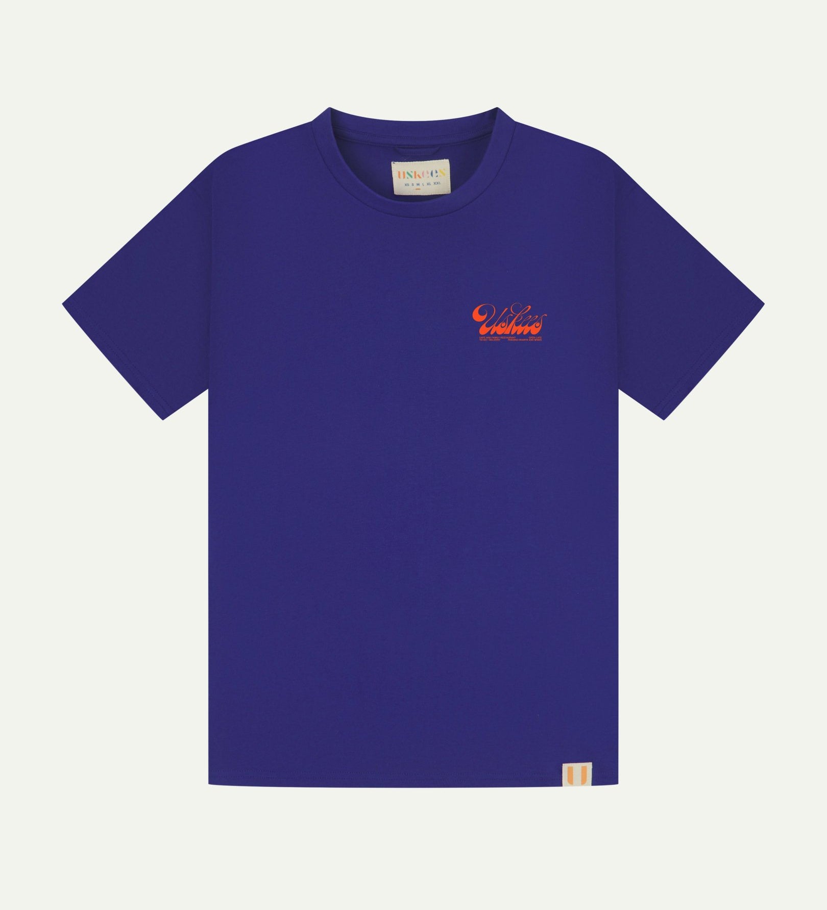 Full flat view of ultra blue organic cotton Uskees T-shirt for men, showing the small bright orange 'diner' logo on the breast.