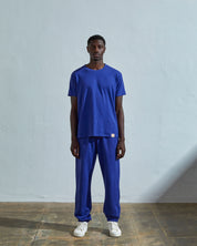 Full-length front view of model wearing ultra blue organic cotton #7006 jersey T-shirt by Uskees paired with matching pants.