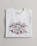 Close-up of white men's t-shirt with focus on deconstructed Uskees logo echoing the form of neolithic stones.