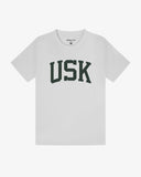 Full flat view of white organic cotton signature T-shirt for men, showing the dark green varsity inspired 'USK' logo on the chest and the Uskees branding labels on the neck and hem.