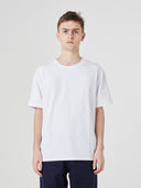 Top-half view of model wearing 7006 white organic cotton t-shirt, paired with Uskees dark blue pants