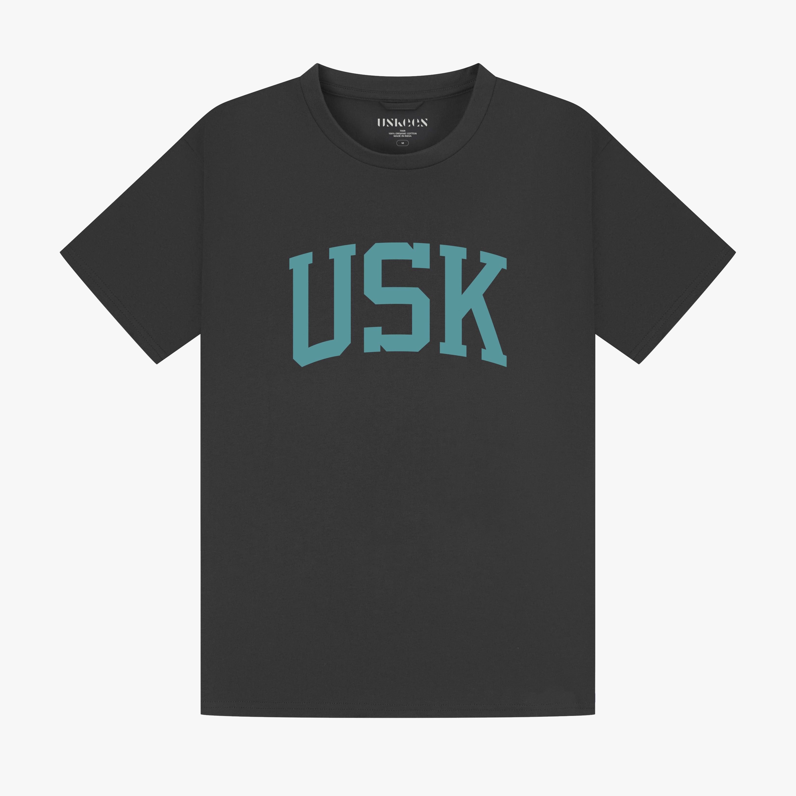Full flat view of faded black organic cotton signature T-shirt for men, showing the varsity inspired 'USK' logo on the chest and the Uskees branding labels on the neck and hem.