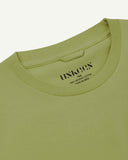 Close-up of a light green men's t-shirt with an Uskees brand label on a white background