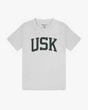 Full flat view of white organic cotton signature T-shirt for men, showing the varsity inspired 'USK' logo on the chest and the Uskees branding labels on the neck and hem.