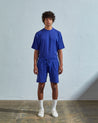 Front view of model wearing ultra-blue, relaxed cut organic cotton #7007 jersey shorts by Uskees with focus on drawstring and loose fit.