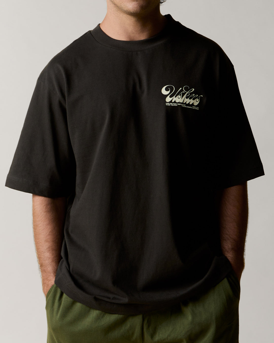 Front view wearing the uskees men's 'diner' tee in black demonstrating the loose, oversized fit.