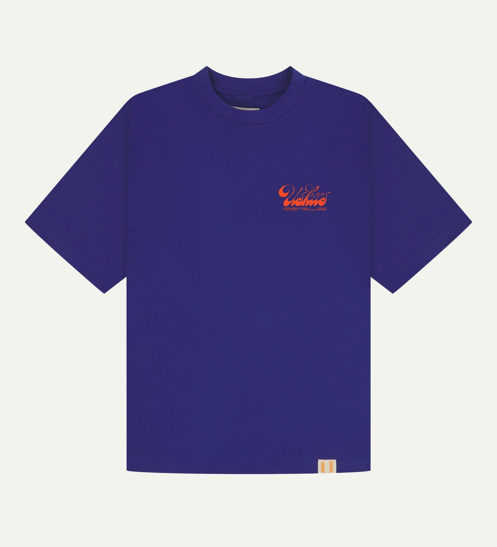 Full flat view of oversized ultra blue organic cotton Uskees T-shirt for men, showing the small bright orange 'diner' logo on the breast.