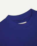 Neckline close-up of ultra blue organic cotton oversized T-shirt showing hanging loop and Uskees branding label.